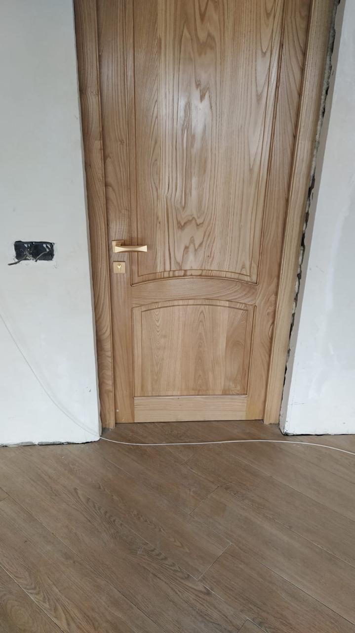 ხის შიდა კარი და დაგებული ხის ფაქტურის იატაკი