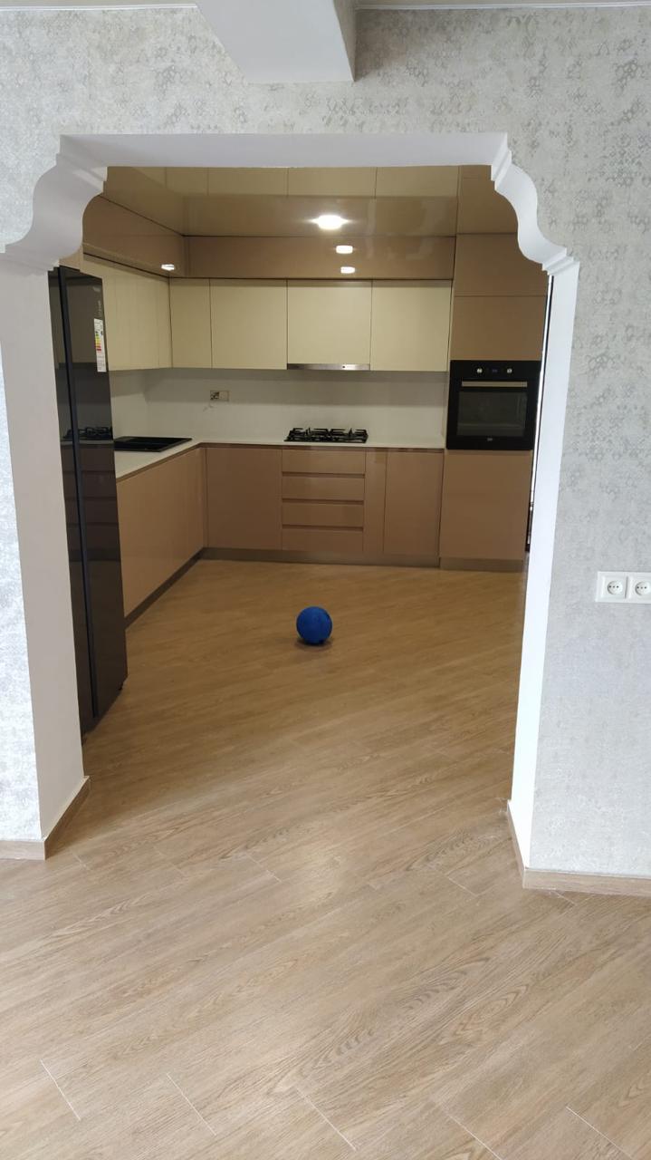 დასრულებული სამზარეულოს სივრცე ჩაშენებული ავეჯითა და განათებით